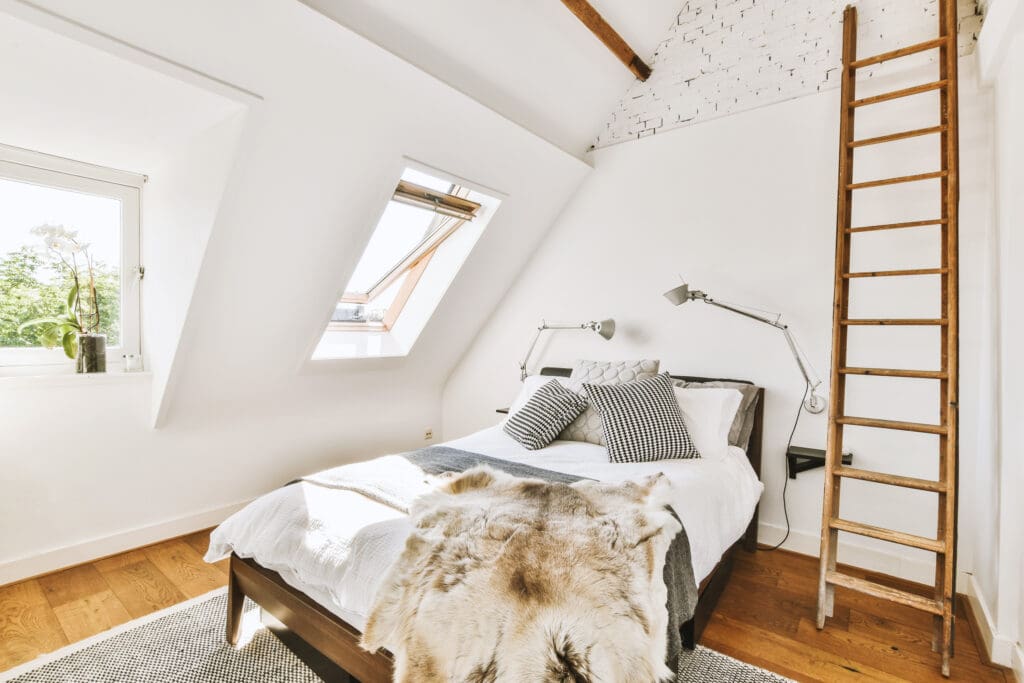 White bedroom with a Velux window in the roof.